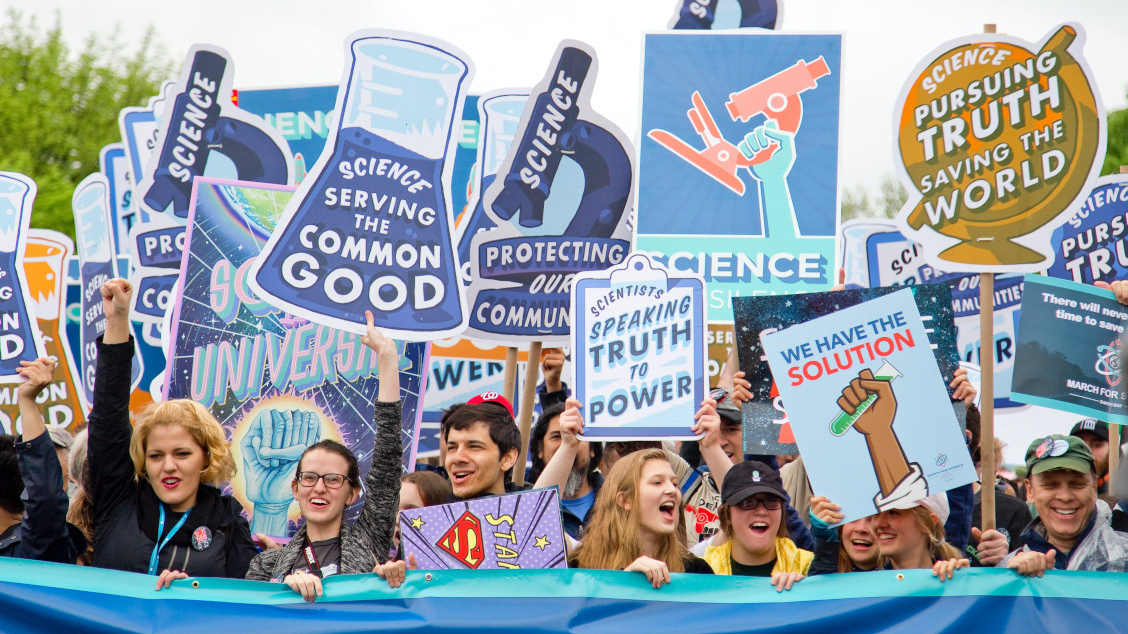 A group of citizen scientists holding signs