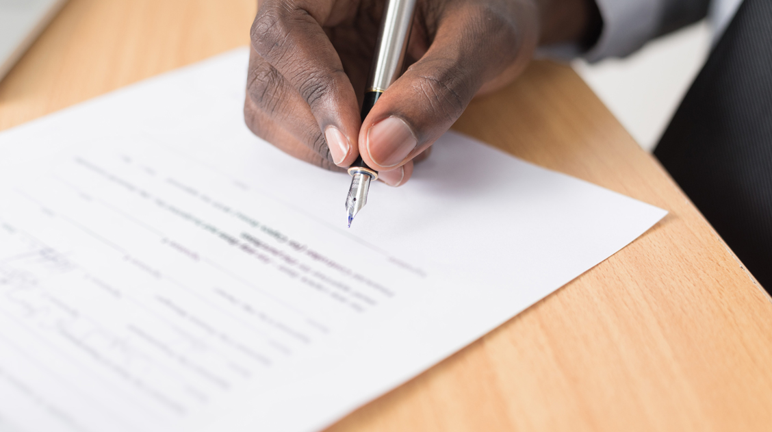 Picture of a man signing a document for society MDPI affiliations program.