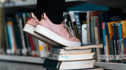 Work–life balance: standing on some books in a library.