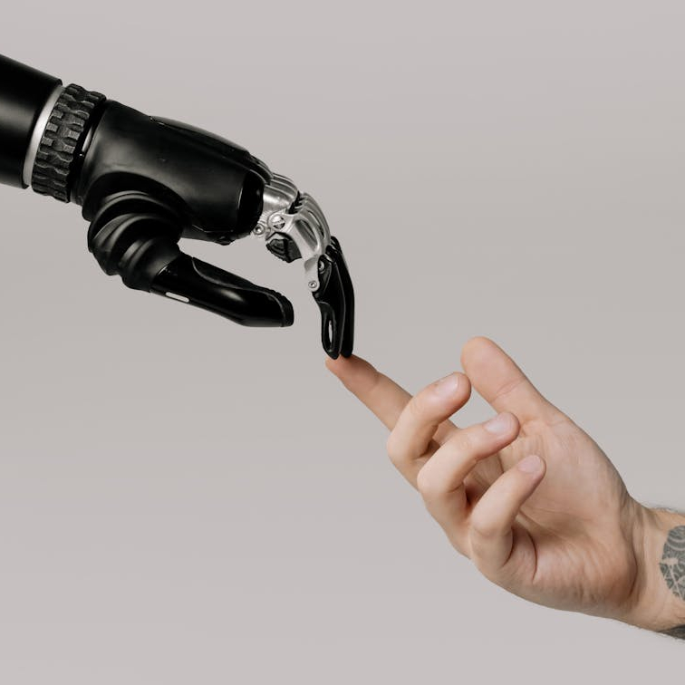 A robot hand and a human hand touching to represent AI