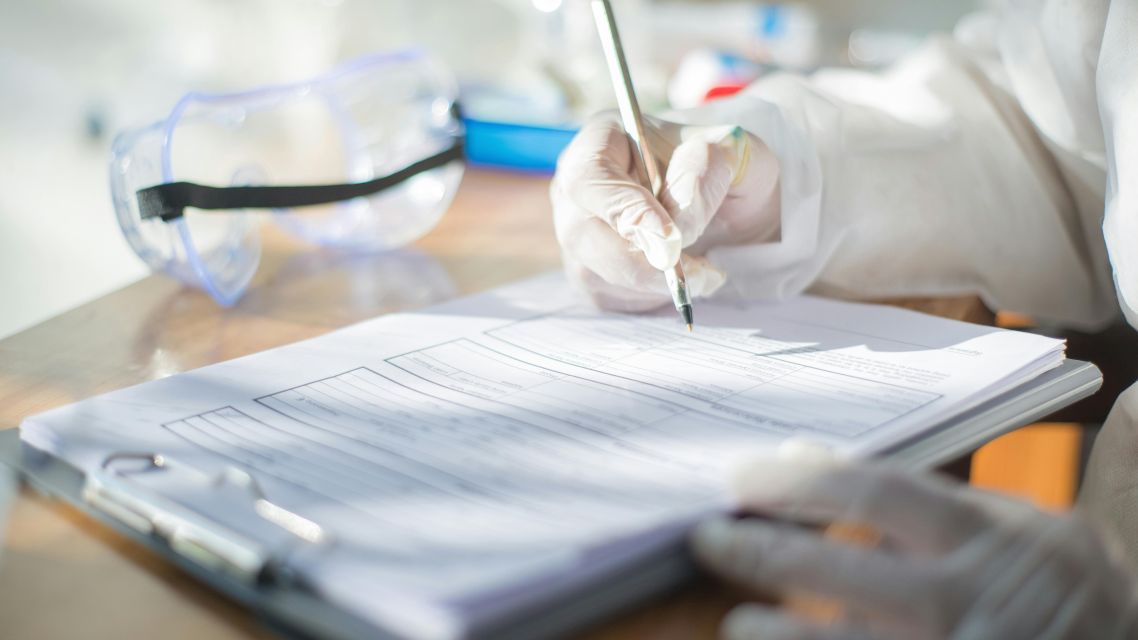 A person writing modal verbs during a scientific study.