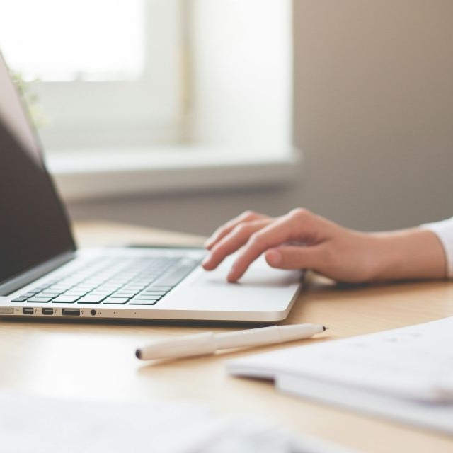 A woman at a laptop performing academic editing.