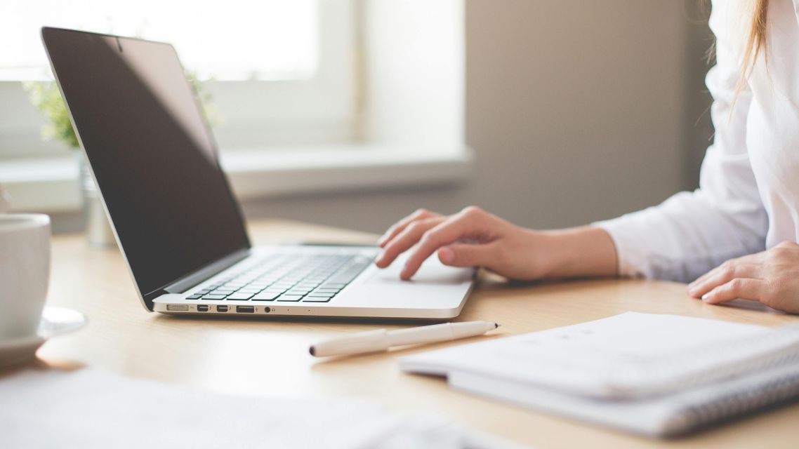 A woman at a laptop performing academic editing.