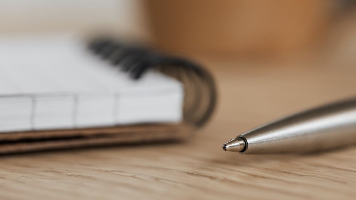 A pen ready to write out conjunctions on a piece of paper.