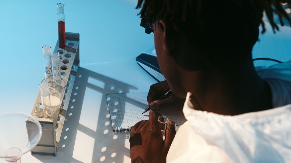 A scientists writing whislt conducting an experiment.