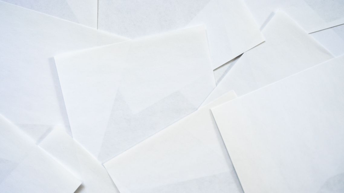 Many blank pages overlaid on top of each other symbolising desk rejection in academic publishing.