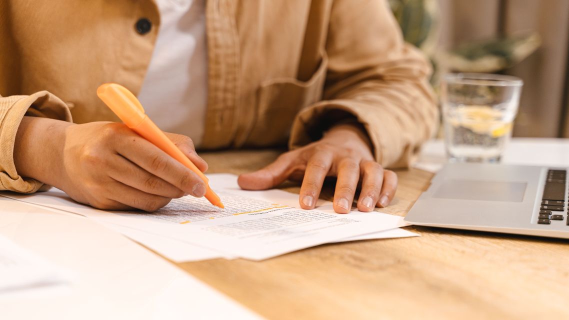 A person making notes on a research paper.