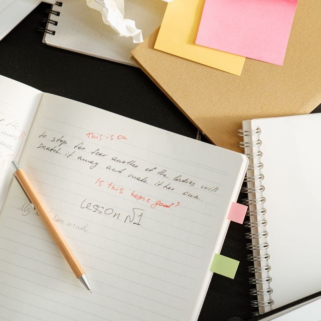 Notebook with writing and comments inidicating the revision process.