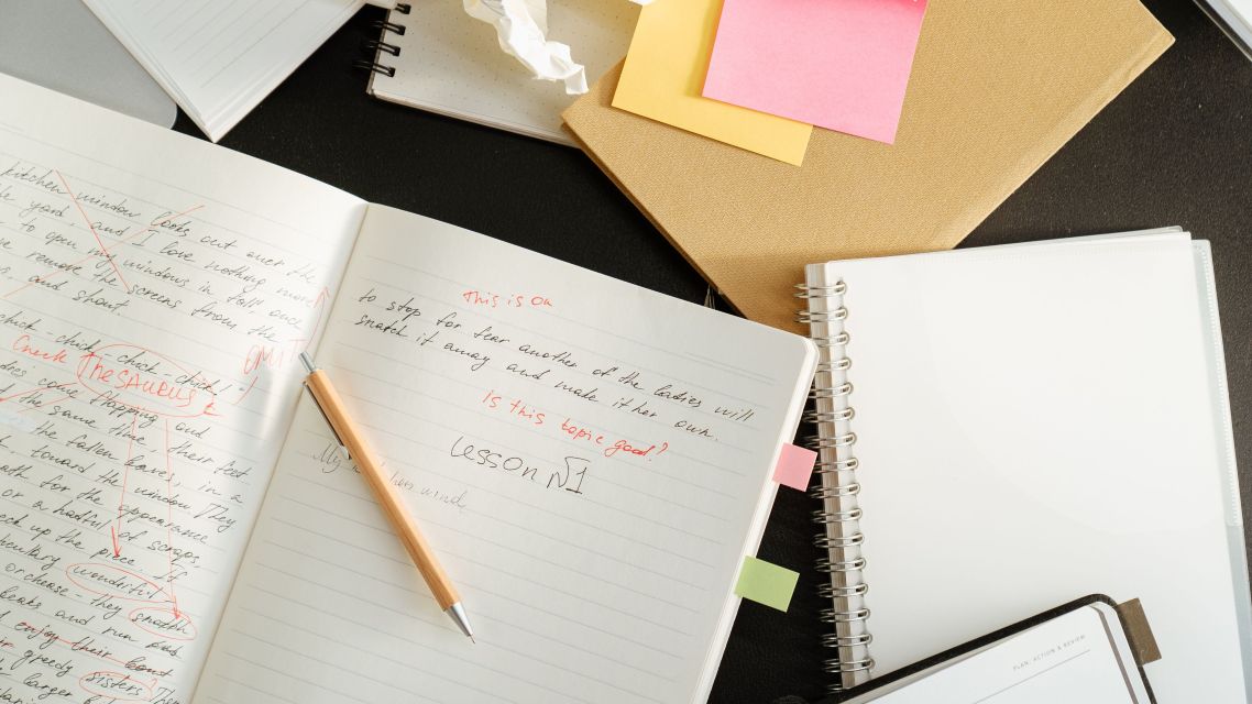 Notebook with writing and comments inidicating the revision process.